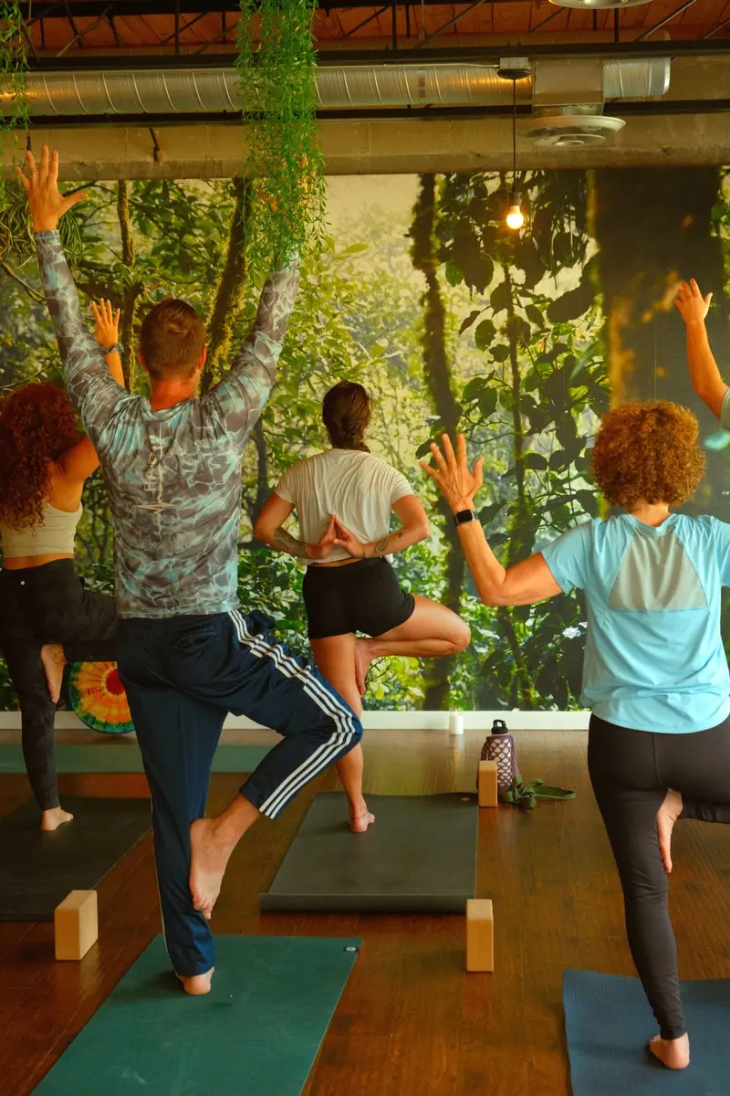 A grounded standing balance pose during a class at Half Pigeon Yoga